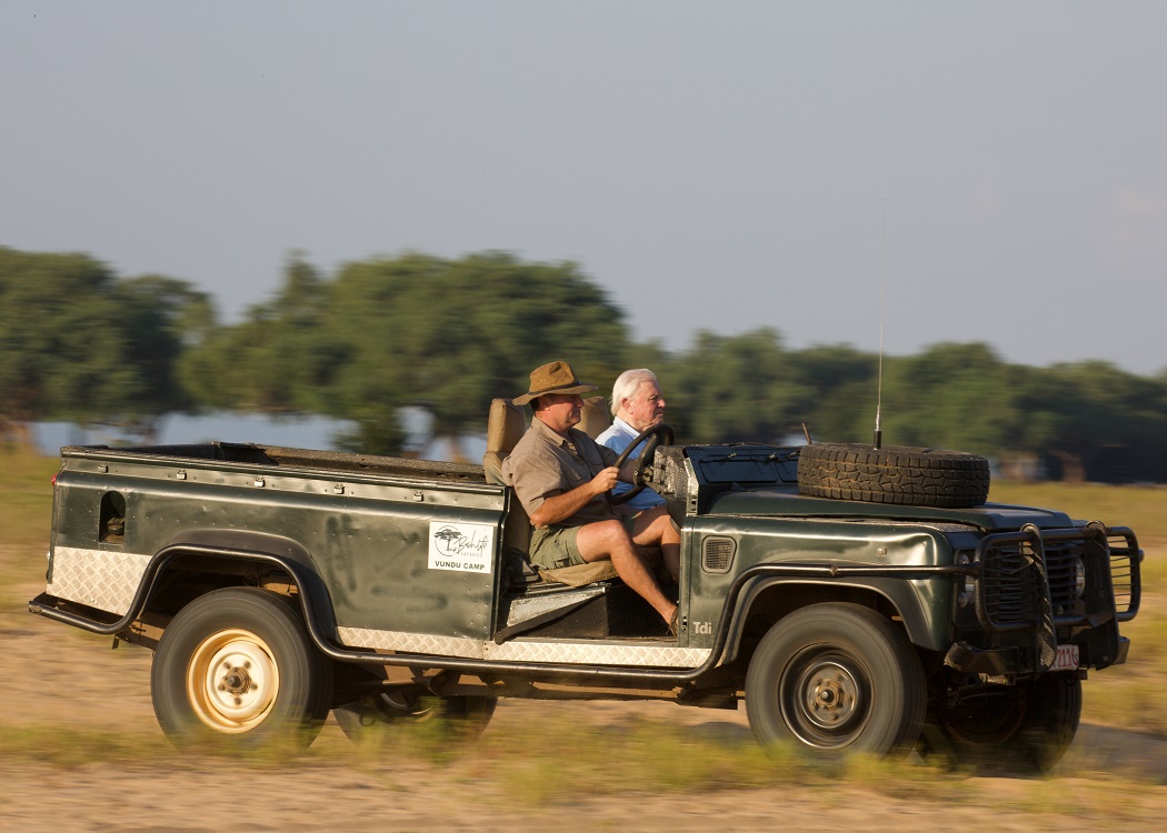SirD+Nick-1050x750 Image of Sir David Attenborough and Nick Murray in a Landrover in Mana Pools on location filming BBC Dynasties about wild dogs.